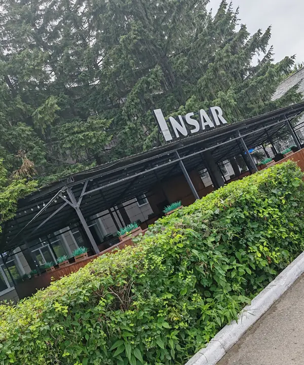 Летник комплекса Insar с вывеской, живая изгородь вдоль дорожки